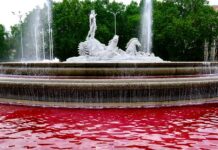 Activistas de Greenpeace tiñen de rojo sangre el agua de la fuente de Neptuno, en las inmediaciones del Congreso, para pedir un embargo de armas a Israel