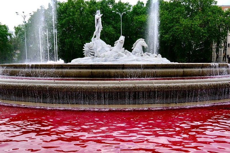 Activistas de Greenpeace tiñen de rojo sangre el agua de la fuente de Neptuno, en las inmediaciones del Congreso, para pedir un embargo de armas a Israel
