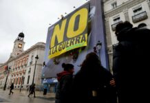Greenpeace descuelga una pancarta gigante en la Puerta del Sol de Madrid con el «NO A LA GUERRA», un clamor popular por la paz y la humanidad Greenpeace descuelga una pancarta gigante en la Puerta del Sol de Madrid con el "NO A LA GUERRA", un clamor popular por la paz y la humanidad