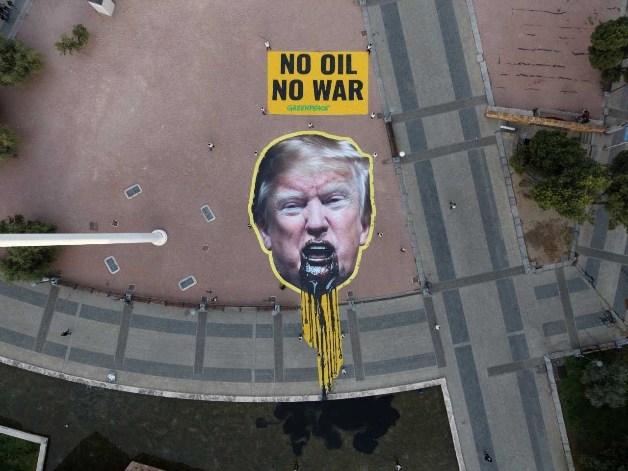 Greenpeace despliega una pancarta gigante de Trump vomitando petróleo para exigir el abandono de los combustibles fósiles